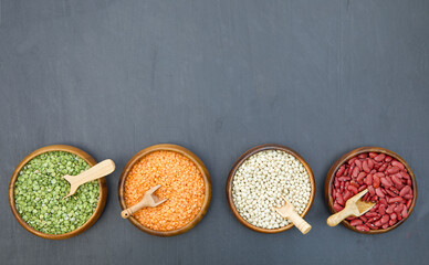Mix of different leguminous plants and spices. Flat lay of various sources of vegetable protein: beans, lentils, peas, chickpeas, mung bean in bowls. Top view. Copy space.