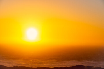 Fototapeta na wymiar Sun shining through Mist at Ocean, Sunset
