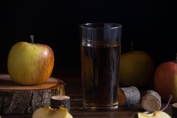 Glass of apple juice with red apples on a wooden table, close up 