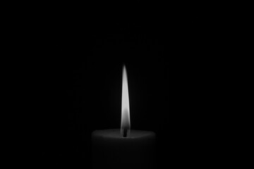 Candle flame close up on black background. Black and white photo. 