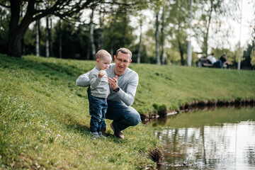 happy family on the bank near the river in summer in the park. Concept of family vacation in nature. dad and kids, father's day