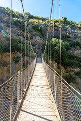 Fototapeta na wymiar Wooden suspension bridges in the Loriguilla reservoir. Ruta de los Pantaneros in the town of Chulilla in the Valencian community. Spain