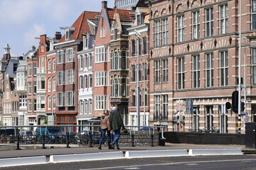 Fototapeta na wymiar Amsterdam Scheepsgracht Canal Street View with Building Facades and Walking Couple