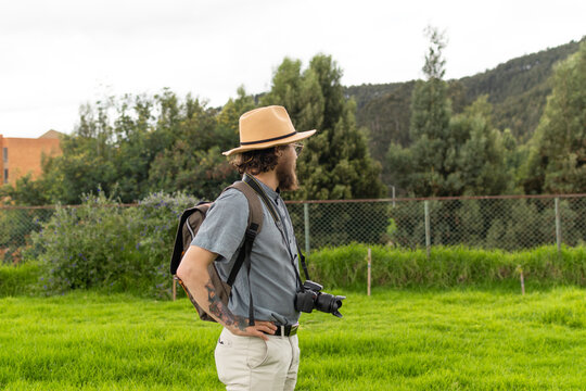 Photographer explorer with hat and glasses contemplating nature