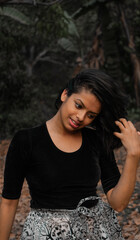 Portrait of a beautiful young woman playing with her hair as it's falling on her face smilingly...