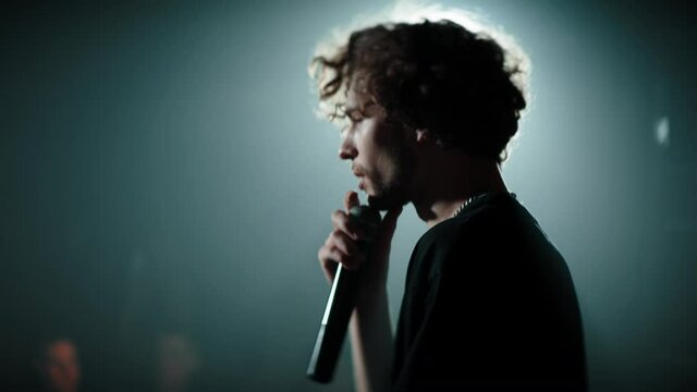 CU Portrait of young Caucasian male comedian performing his stand-up monologue on a stage of a small venue. Shot with ARRI Alexa Mini LF with 2x anamorphic lens