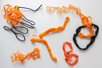 abstract composition with embroidery floss or thread (mostly in bright orange cotton) and wire...