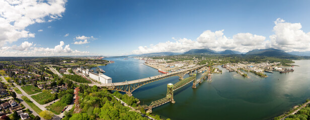 Aerial panoramic view of an Industrial Site and Second Narrows Bridge during a sunny spring day....