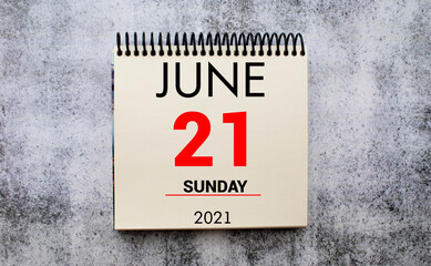 June 21st. Day 21 of month, daily calendar on white table with reflection, with light blue background.