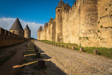 Fototapeta na wymiar Towers and stone walls from inside the fortified precinct de la Cite in the medieval city of Carcassonne at sunrise, UNESCO World Heritage Site, France