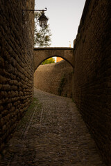 Arch between stone walls in a street in the Cite of the medieval city of Carcassonne at sunrise, UNESCO World Heritage Site, France