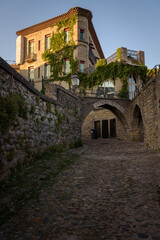 Stone old building in the background of a alley with stone walls in the Cite of the medieval fortified city of Carcassonne at sunrise, UNESCO World Heritage Site, France