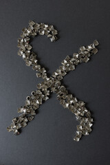 old, worn, recycled square pyramidal metallic studs or spikes arranged in the shape of a stylized...