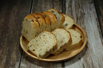 Pile of sliced whole wheat bread and grains serving on the wooden plate. Classic healthy breakfast menu in the morning. 