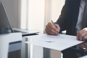 Businessman signing official contract on table in modern office