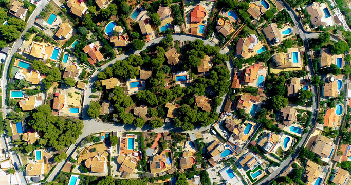 Aerial view with a drone above beautiful villas in a suburban community in Spain. Perfect family environment for everyday life. We can see rooftops and garden 4K 