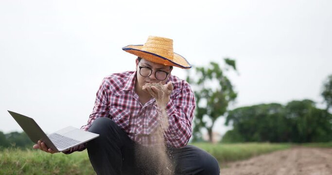 Smart farmer man cheking a soil with laptop