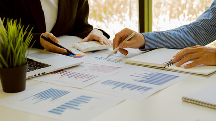 Business people doing business in finance and calculating, analyzing, graphing the cost of...