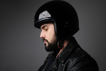 Bearded young male model wears biker helmet and leather jacket.