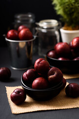 Japanese or Chinese red plum fruit in a bowl on black background