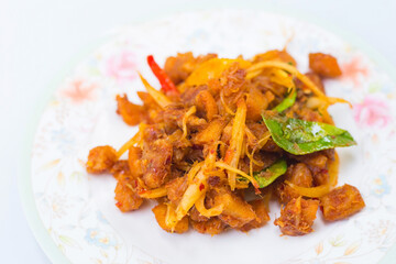 Stir-Fried Pork Crackle with Curry Paste made from the fat of pork contains herbs such as chili, ginger, kaffir lime leaves, a delicious traditional Thai food.