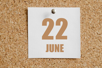 june 22. 22th day of the month, calendar date.White calendar sheet attached to brown cork board.Summer month, day of the year concept