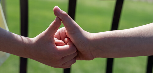 Two children playing a thumb war battle with the objective to pin the opposing player's thumb