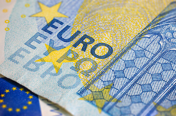 Obraz premium Fragment part of 20 euro banknote close-up with small blue details. Closeup of the twenty euro banknote, Euro currency money. Oblique detailed macro view. New Europe paper money. European Union cash