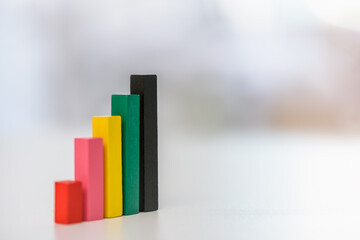 Financial business growth or sales performance increase concept : Increasing height, color wood bar graphs on a table, depicts increasing of productivity or challenging amount on competitive market