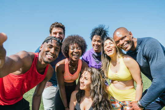 Group of runners taking a selfie in a park. Happy and smiling.