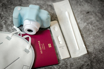 Travel concept with SARS-CoV-2 Rapid Antigen Test, passport and photocamera