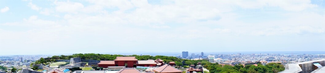 Fototapeta premium Aerial view of Naha city and sea shore from Shurijo castle in Okinawa, japan. Panorama - 沖縄 那覇市の街並みと海 パノラマ