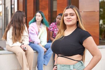 Young Hispanic woman in front of her friends. Multi-ethnic group