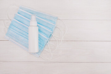 Medical masks and antiseptic masks on a white wooden background.