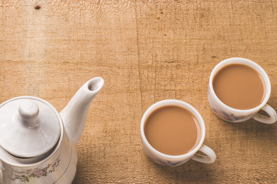Indian chai in glass cups with metal kettle and other masalas to make the tea.