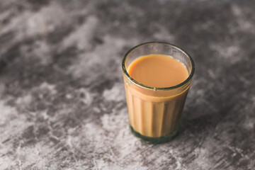 Indian chai in glass cups with metal kettle and other masalas to make the tea.