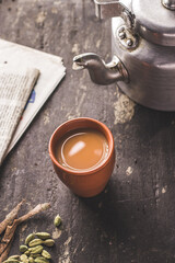Indian chai in glass cups with metal kettle and other masalas to make the tea.