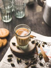 Indian chai in glass cups with metal kettle and other masalas to make the tea.
