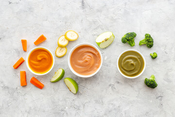 Set of bowls with baby food with fruits and vegetables. Kid feeding, top view