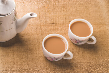 Indian chai in glass cups with metal kettle and other masalas to make the tea.