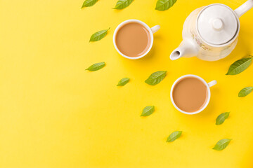 Obraz na płótnie Canvas Milk tea on white cup with white kettle on yellow background stock image.