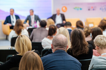 Speakers discussing business problems in auditorium