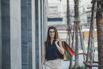 Young woman with shopping bags. Happy woman with shopping bags enjoying in shopping. lifestyle concept. Fashion woman with shopping bags walking on street.