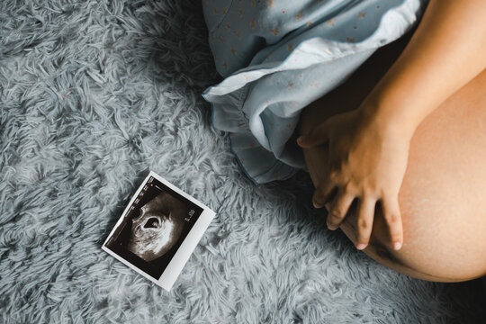 Pregnant women and ultrasound pictures Piggy bank with a stethoscope on the couch inside the house. Ideas for preparing to save money for pregnancy, complete parenting
