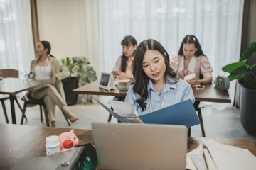 Women asian working together, at office. young business woman reading sitting at the desk on office background