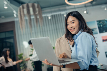 Business woman working online on a laptop. Portrait of a happy asian businesswoman working on laptop computer