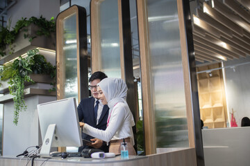 young Asian reception team hotel front desk welcoming . Asian reception welcoming the customer into hotel front desk counter for service the customer,