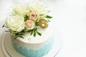 wedding  anniversary   cake  decorated  white and turquoise cream with natural roses and  gold...