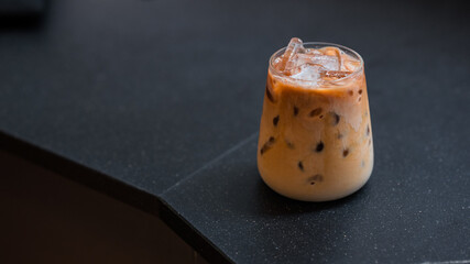 Close-up of iced coffee served on black table at cafe​