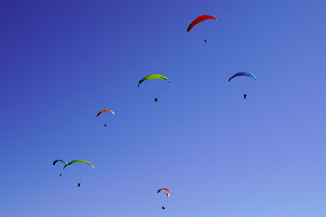 parachute paragliders enjoy a thermal updraft in Puy de Dome blue sky in Auvergne French Massif Central France